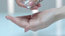 Pharmaceutical pills in hand. Woman pour antibiotic tablet from blister pill Stock Footage