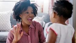 Mother singing song to baby daughter into air and smiling - shot in slow motion Stock Footage