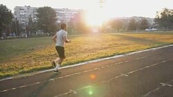 Mixed race athlete running on an all-weather running track alone Stock Footage