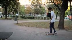 Skateboarder riding skateboard through the public park Stock Footage