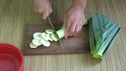 Cut fresh leek on chopping board in kitchen Stock Footage