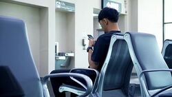 Young Asian man using mobile phone touchscreen and talking on phone. working on the phone, in the background of a Airport , planes, Concept: new business, travel, communication. Stock Footage