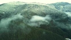 aerial of mountain valley on the winter snowy day through the clouds. Stock Footage
