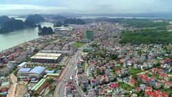 4k Aerial view over city and park with Bai Tho karst mountain Ha long bay. Halong City. Stock Footage