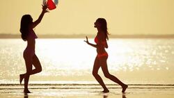 Multi ethnic girlfriends on ocean beach at sunset Stock Footage