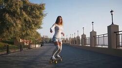 Young stylish attractive woman skateboarding at sunrise on seafront, slow motion Stock Footage