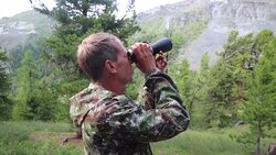 The tourist looks through the binoculars to the mountains. Stock Footage