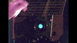 UNITED STATES 1960s: Man in darkroom, tilts photos under glass. Stock Footage