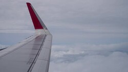 Airplane flight. Wing of an airplane flying above the clouds from window plane view Stock Footage