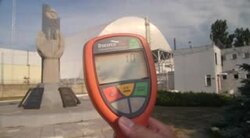 Handheld geiger counter in front of Chernobyl power plant News Clip