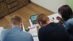 Analysts at desk work at laptop showing statistics, looking at graphs and charts Stock Footage