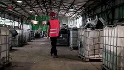 Adult man, worker in waste disposal dump walking past waste containers Stock Footage
