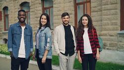 Slow motion portrait of beautiful young people men and women standing outdoors in the street smiling and looking at camera. City, friendship and youth concept. Stock Footage