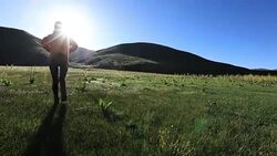 Young woman hiking in high land grassland mountains Stock Footage