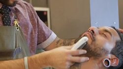 Barber shaves customer with straight razor blade Stock Footage