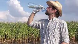 Tired thirsty farmer is drinking water in field Stock Footage