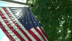 Sunshine and lens flare highlighting American flag from Revolutionary War Stock Footage