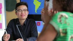 Biology Teacher Sitting With Students Helping Them With Work Stock Footage