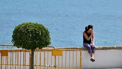 Wide Angle: Woman Sitting on Seawall Stock Footage