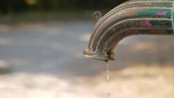Dripping water from a water tap in a light park. Stock Footage