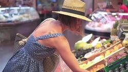 Attractive young woman choosing peaches at marketplace Stock Footage