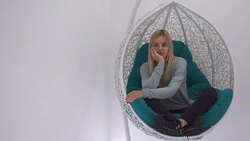 Beautiful girl thumbs a magazine in the chair Stock Footage