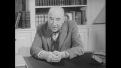 1960s: Man with bowtie in study addresses viewer Stock Footage