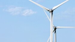 Wind turbines and agricultural fields on a summer day Stock Footage