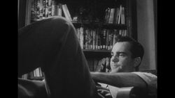 1950s: Restless husband flips through book Stock Footage