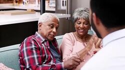 Senior couple meeting with financial advisor and designing documents at home - shot in slow motion Stock Footage