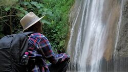 Close Up Senior man enjoying sit in front of the waterfall.  Lifestyle Travel Adventures and tourism  with backpack. Video Slow motion Stock Footage