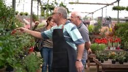 Family shop for plants with Salesman at Flower Market Stock Footage