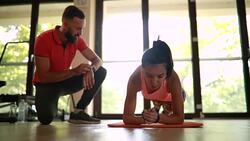 Young athletic woman warming up with a personal trainer Stock Footage