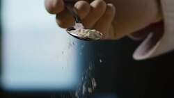 in an Italian professional kitchen a chef pours salt on a dish or in the water to boil the Italian pasta concept of healthy and light food. Stock Footage