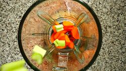 Stalk of an apium fall on carrots in a blender bowl. Slow motion.	Shooting in kitchen. Top view. Stock Footage