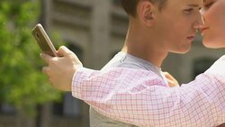 Teen boy and girl embracing, ignoring each other, using smartphones, addiction Stock Footage