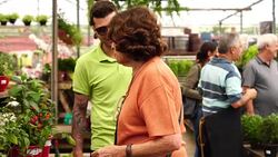 Family shop for plants with Salesman at Flower Market Stock Footage
