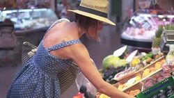 Beautiful young woman picking plums at marketplace Stock Footage