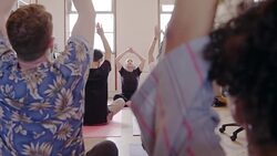 Creative business people practicing yoga in open plan office Stock Footage