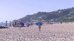 Holiday makers enjoy the sun at Atlanterra Beach News Clip