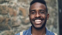 Close-up slow motion portrait of African American male with expressive face smiling showing teeth and looking at camera. Positivity, people and emotions concept. Stock Footage