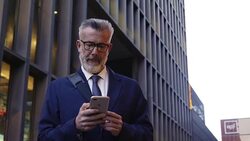Businessman using mobile phone outside office Stock Footage