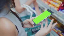 Two young women using smartphone in supermarket,Green screen Stock Footage