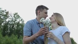 The guy and the girl blow on dandelions Stock Footage