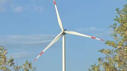 Wind turbines and agricultural fields on a summer day Stock Footage