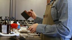 Female hairdresser cleaning scissors in salon Stock Footage