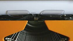 High and side angle footage of a person writing ISLAMOPHOBIA on a typewriter Stock Footage