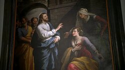 MEDIUM ANGLE OF RELIGIOUS PAINTING WITH JESUS CHRIST BLESSING WOMEN IN TEMPLE. MEN IN BG. COULD BE IN CHURCH. Stock Footage