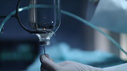 Gloved hand put needle in drop counter. Chemotherapy bottle Stock Footage