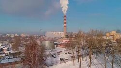 Bad ecology. The thermal power plant located in the center of the residential district, throws out smoke from the high pipe, polluting the atmosphere of the city. Aerial drone video with ascending and forward camera motion. Stock Footage